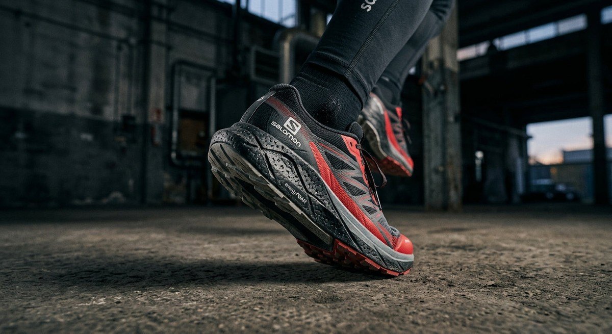 Close-up of the Salomon Aero Glide 5 midsole texture showing high-rebound foam details with a sharp, cinematic focus and moody industrial background.