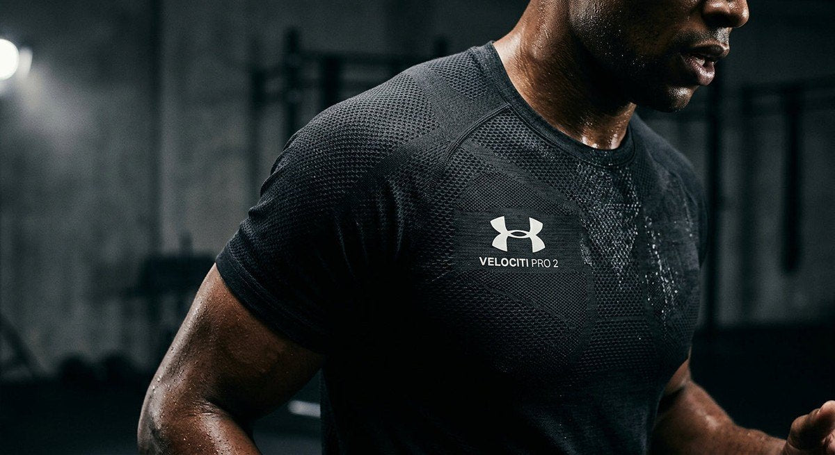 Close-up of the textured, high-performance fabric of the Under Armour Velociti Pro 2 under dramatic, moody studio lighting.