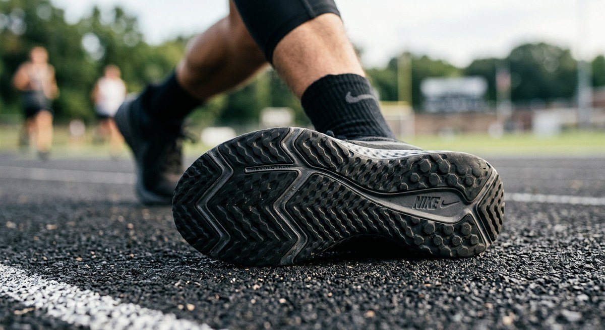 Detailed macro view of the Nike Revolution 9 outsole, focusing on the new lug pattern design and high-traction rubber compound for professional athletic performance.