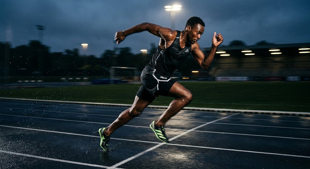 High-speed action shot of an athlete sprinting on a track with motion blur and sharp, moody lighting