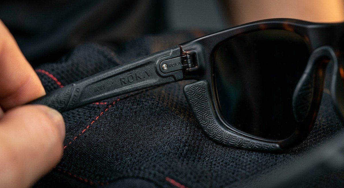 Macro detail photography of the ROKA Rory 2.0 temple hinge and GEKO grip material, showcasing the technical engineering and material quality.