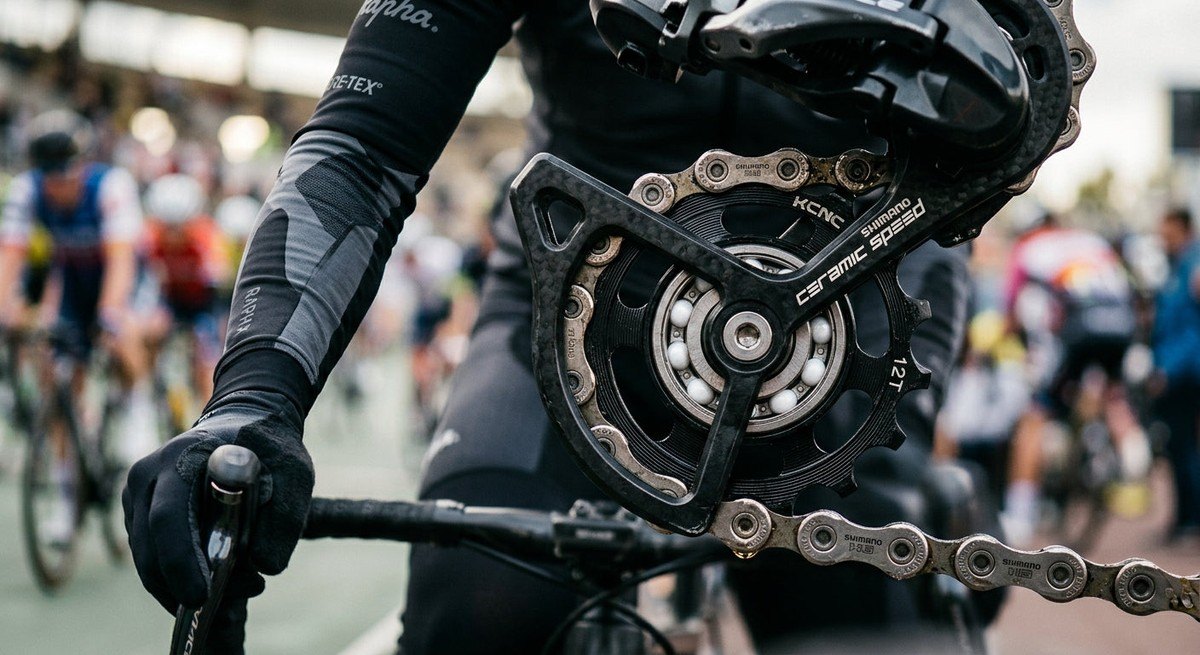 Macro photography of a ceramic bearing, focusing on the refined metal finish and intricate textures of the derailleur pulley.