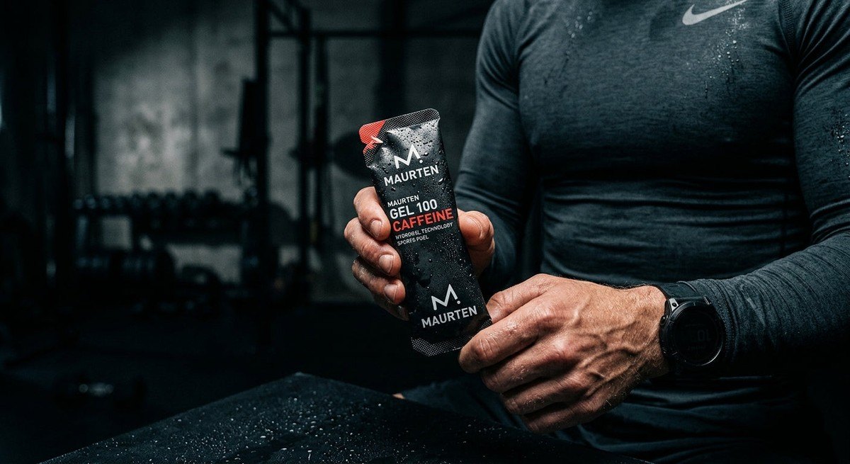 Macro shot of high-performance energy gel packaging against a dark, moody background with subtle water droplets.