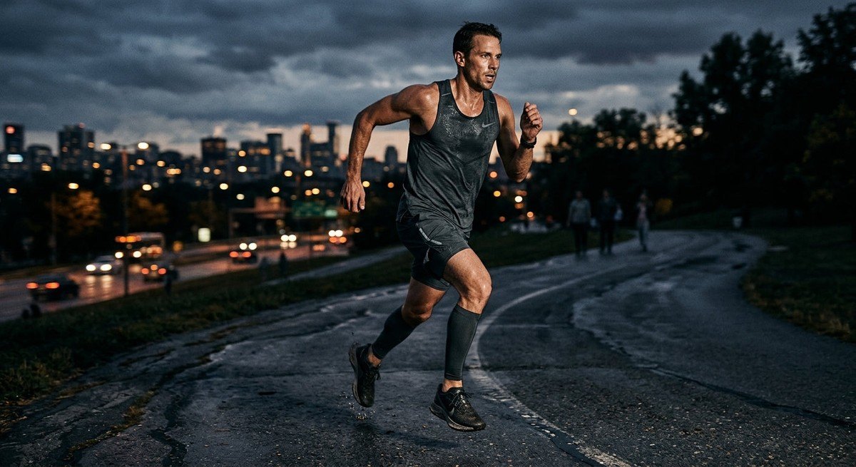 Moody cinematic shot of an athlete in mid-stride during a tempo run, focusing on sharp textures and high-contrast lighting.