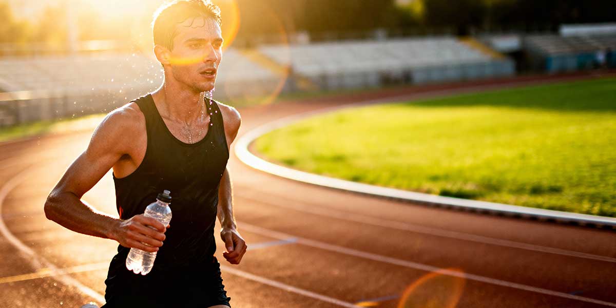 A runner holding a collapsible soft flask water bottle during a morning run.