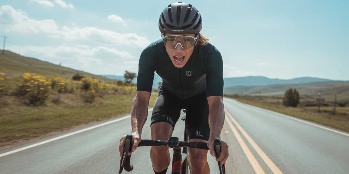 A focused cyclists in Sundried gear exercising outdoors with high energy levels.