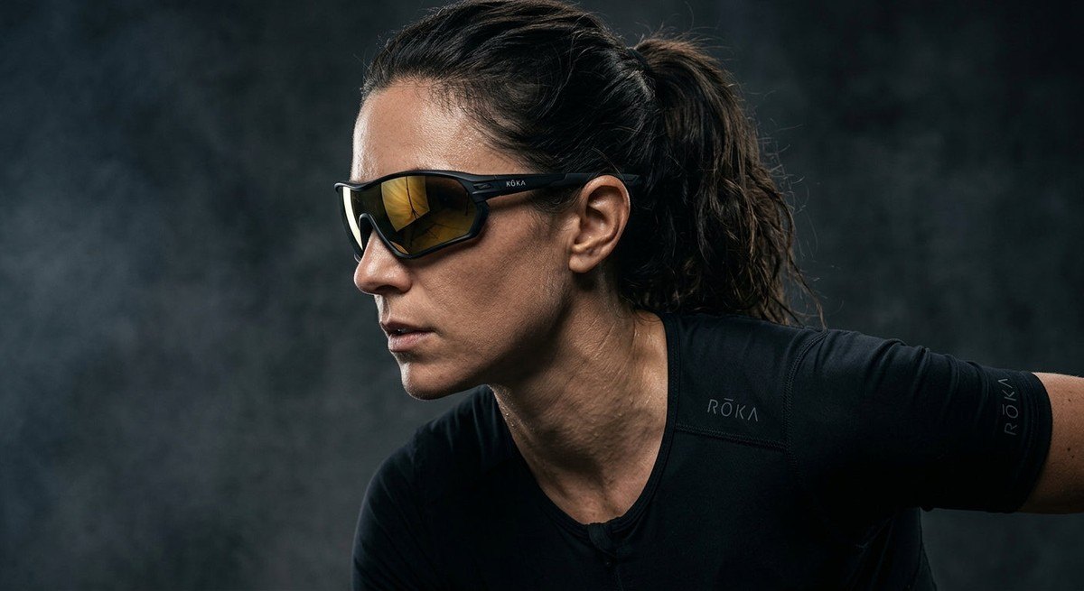 Technical studio shot of the ROKA Cade 2.0 sunglasses demonstrating the curvature and lens geometry against a moody, dark background.